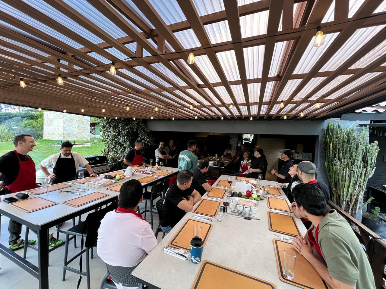 Grupo de amigos sentados en la mesa compartiendo durante el taller de parrilla nocturno