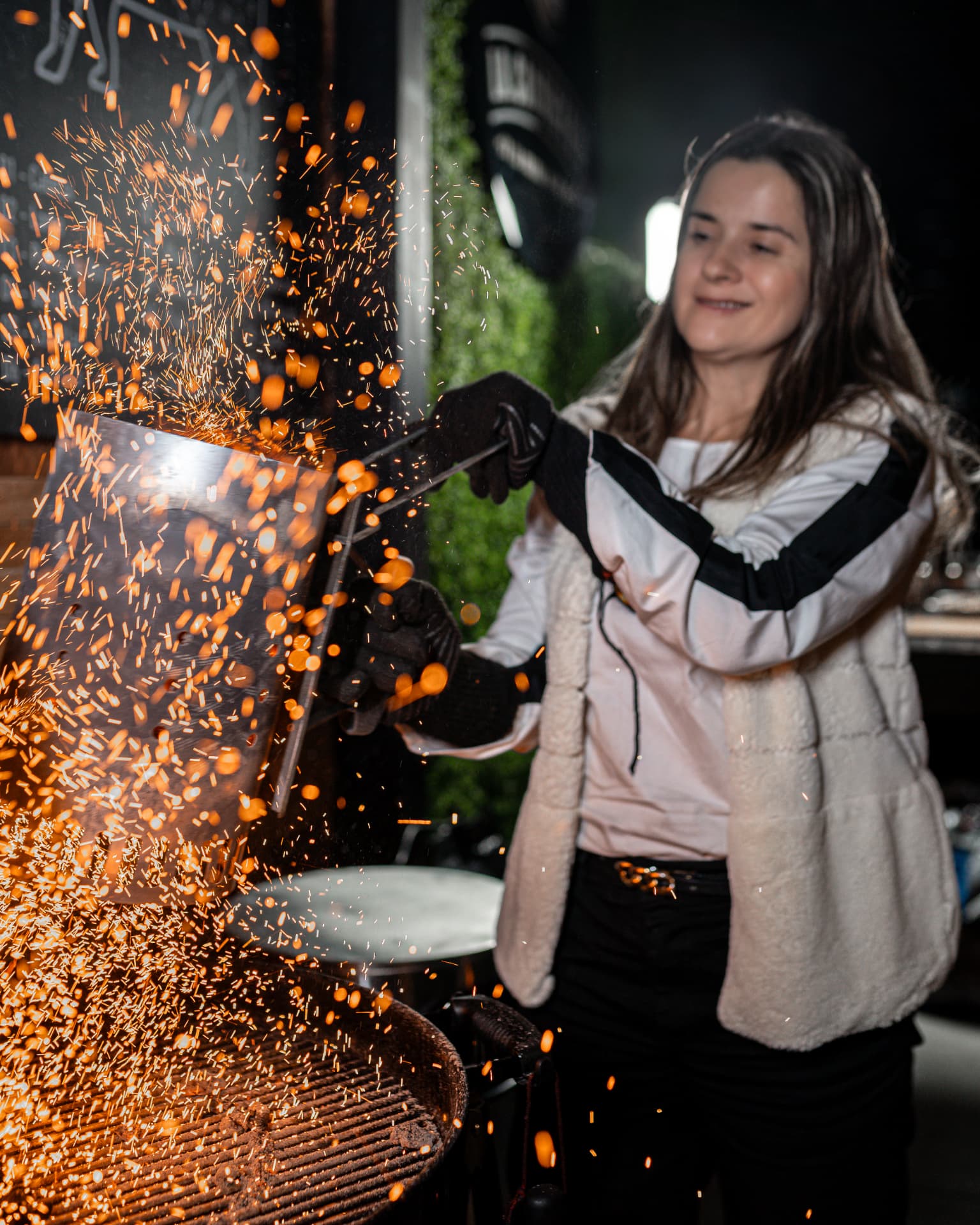Participante encendiendo el carbón de la parrilla entre chispas durante el taller