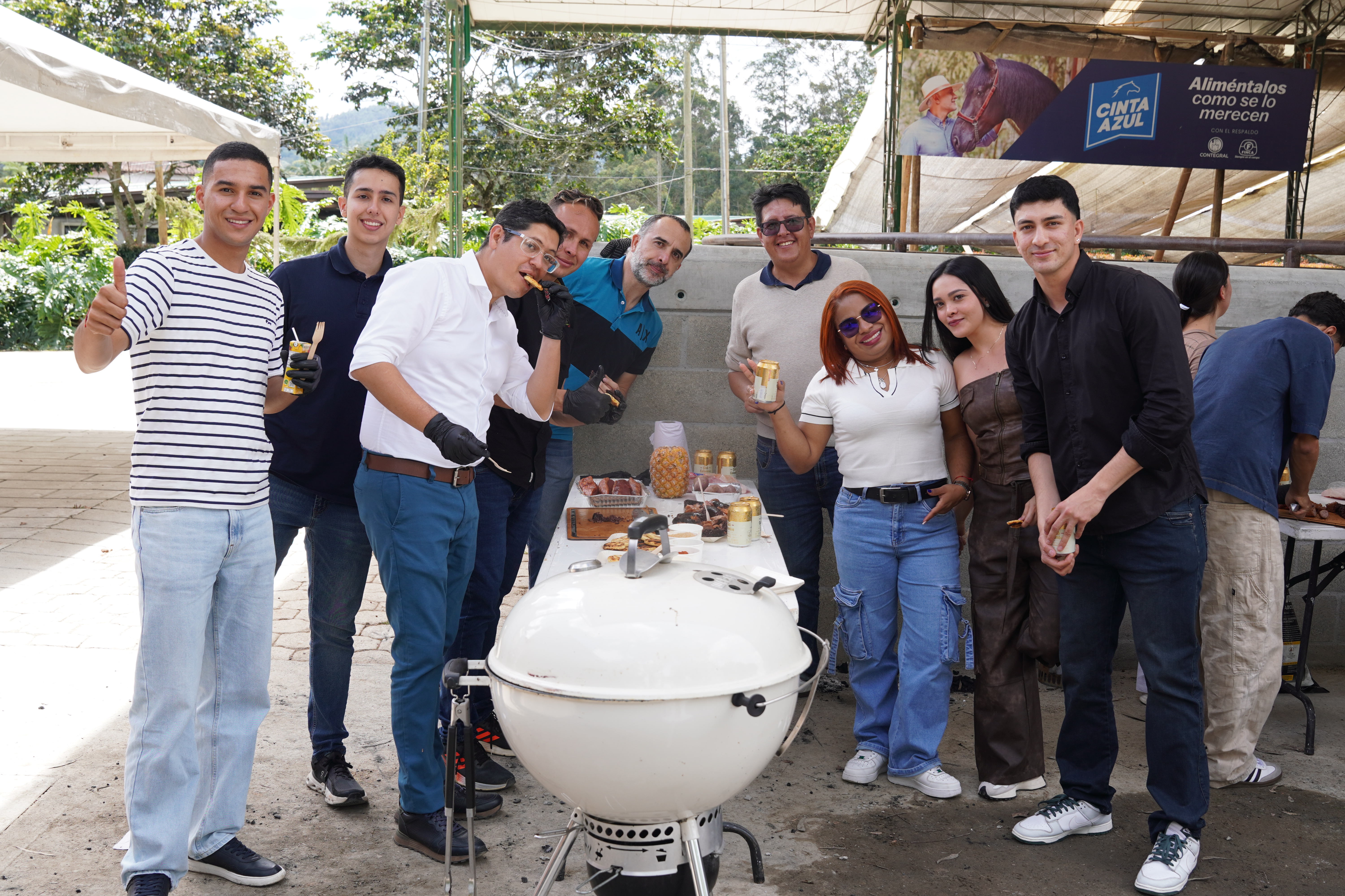 Equipo alrededor de la parrilla durante un taller corporativo de día